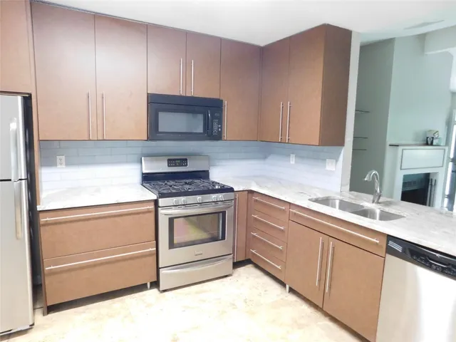 a kitchen with granite countertop a sink and a stove