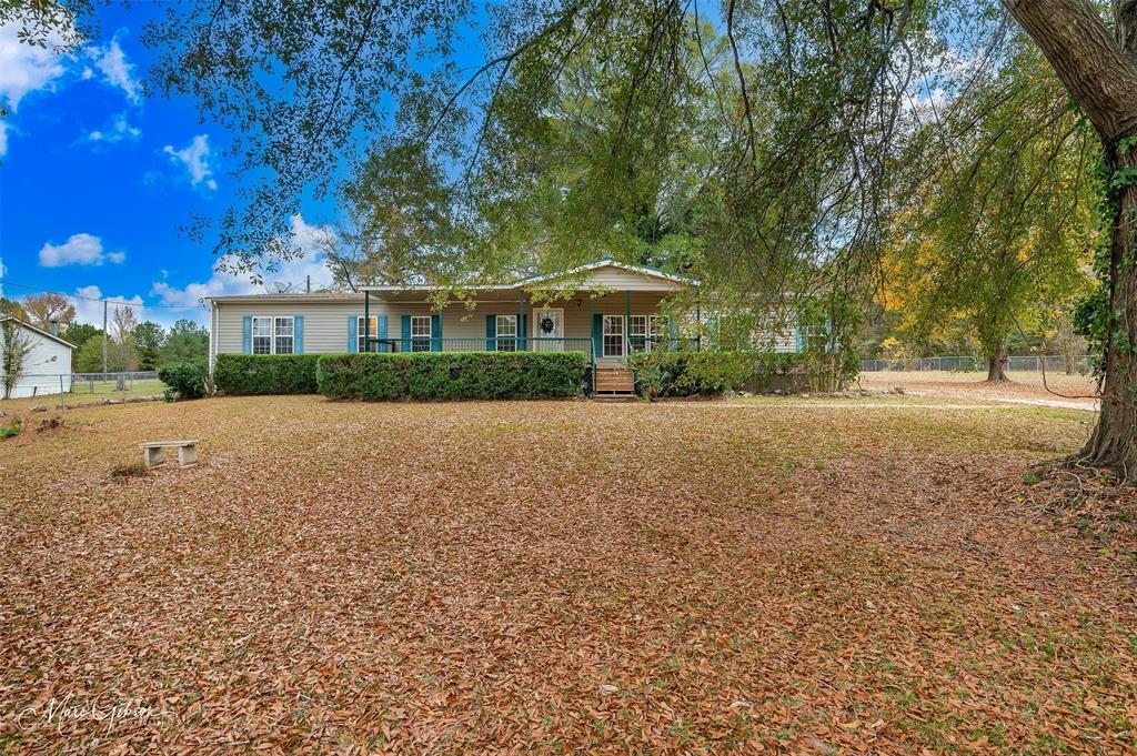 a front view of a house with a yard and trees