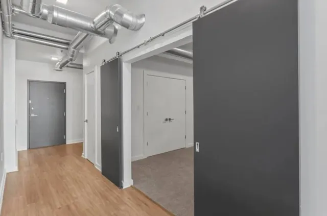 a view of a hallway with wooden floor and a ceiling fan