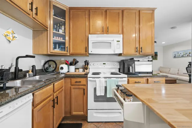 a kitchen with stainless steel appliances granite countertop a sink a stove and refrigerator