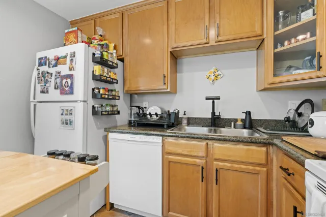 a kitchen with stainless steel appliances granite countertop a stove a sink and dishwasher with wooden cabinets