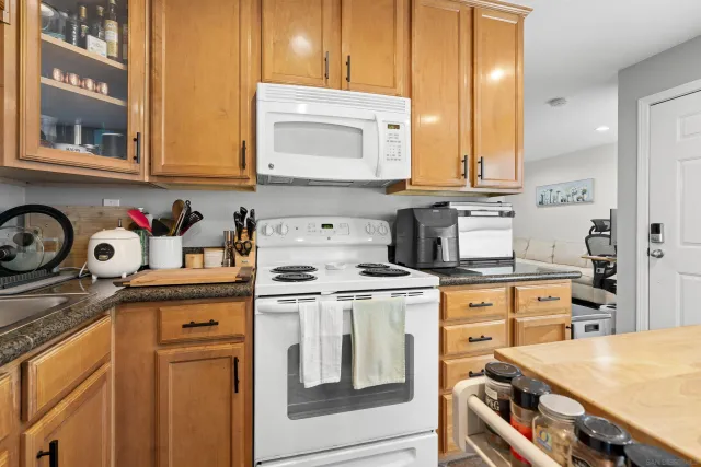 a kitchen with granite countertop a sink stove and cabinets