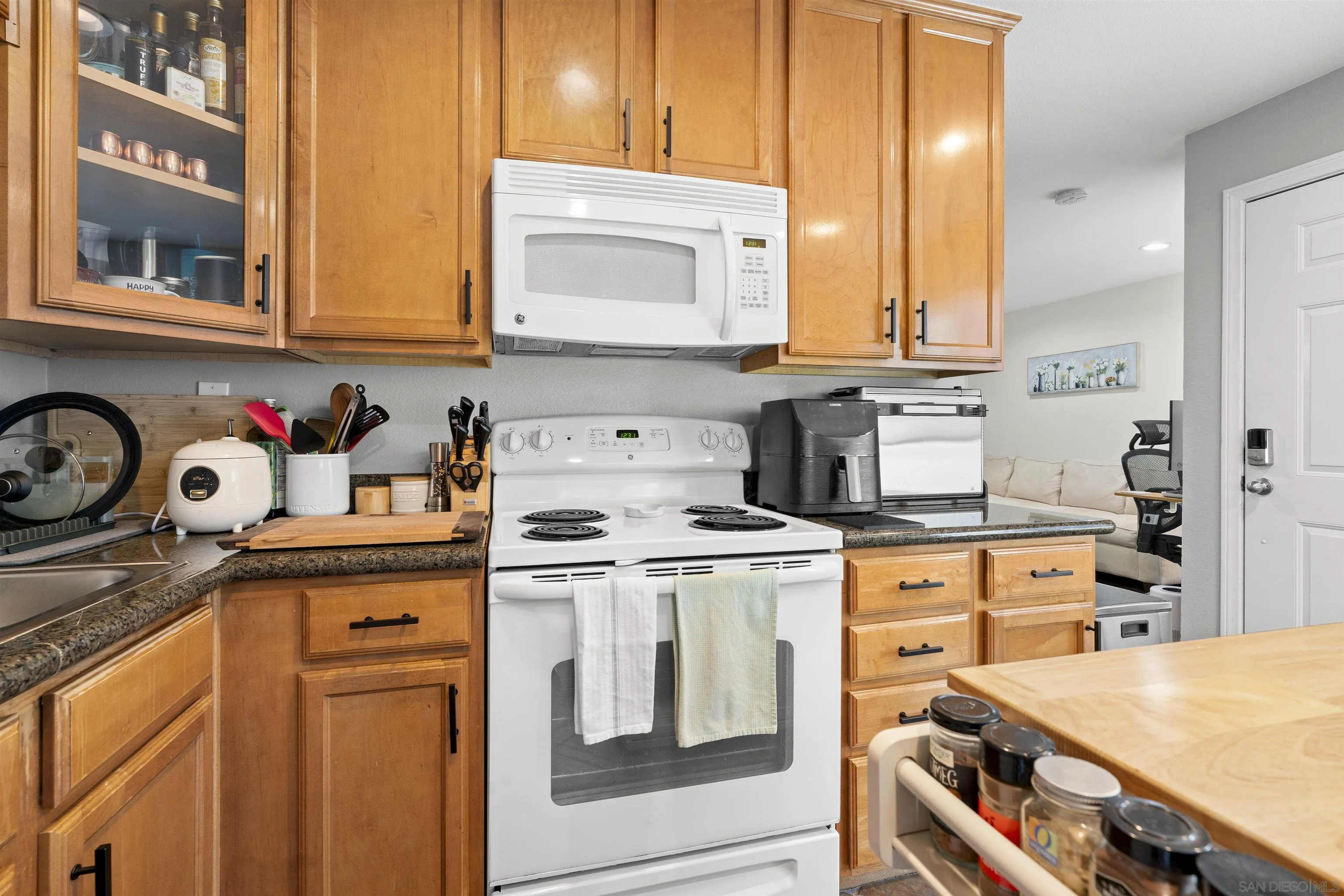 6333 College Grove Way, Unit 1101 (14) San Diego, CA 92115 - Photo 18 of 39 a kitchen with stainless steel appliances granite countertop a stove a sink and dishwasher with wooden cabinets