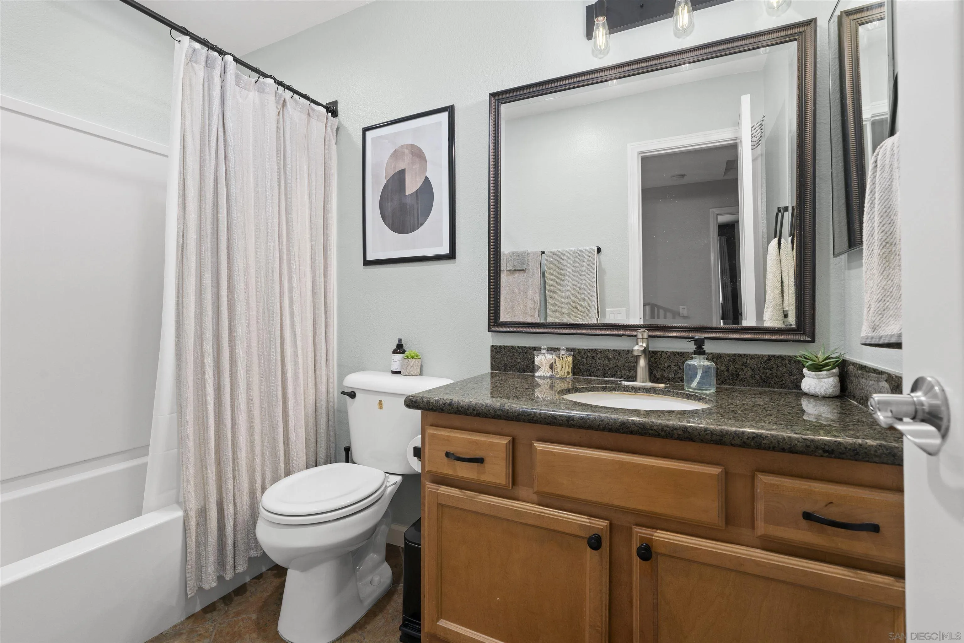 6333 College Grove Way, Unit 1101 (14) San Diego, CA 92115 - Photo 25 of 39 a bathroom with a granite countertop toilet sink and mirror