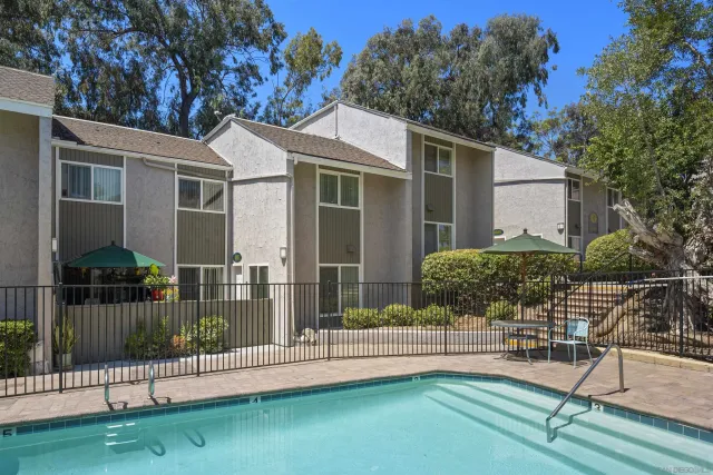 a view of a chair and table in the garden front of house