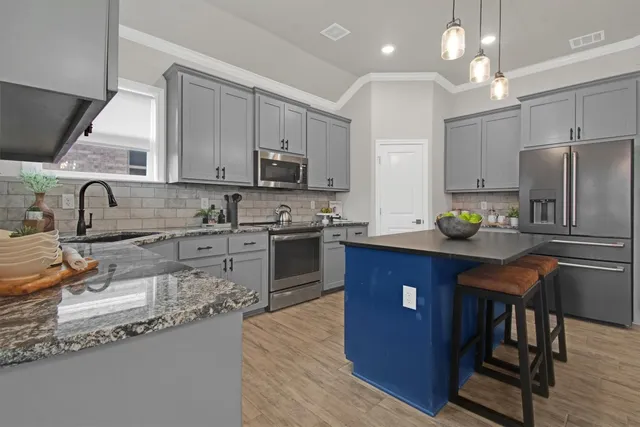 a kitchen with stainless steel appliances granite countertop a sink wooden cabinets and a refrigerator