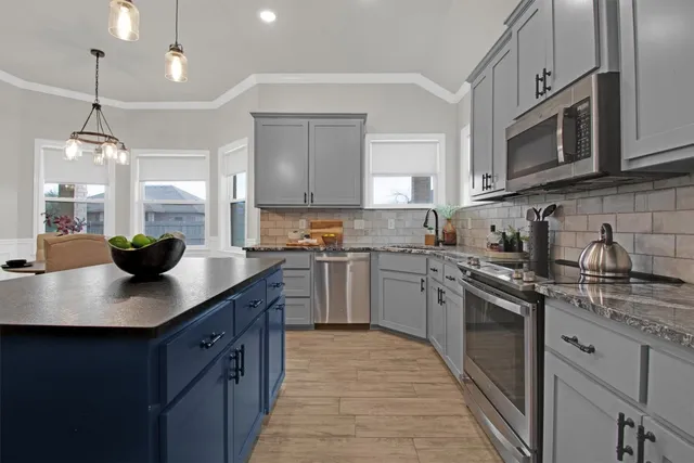 a kitchen with stainless steel appliances granite countertop a sink a stove and cabinets