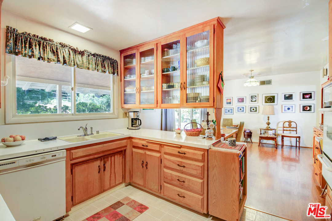 20490 Seaboard Road Malibu, CA 90265 - Photo 13 of 43 a kitchen with stainless steel appliances sink cabinets and wooden floor