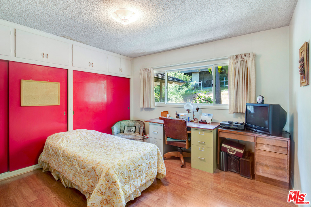 20490 Seaboard Road Malibu, CA 90265 - Photo 30 of 43 a bedroom with a bed and wooden floor