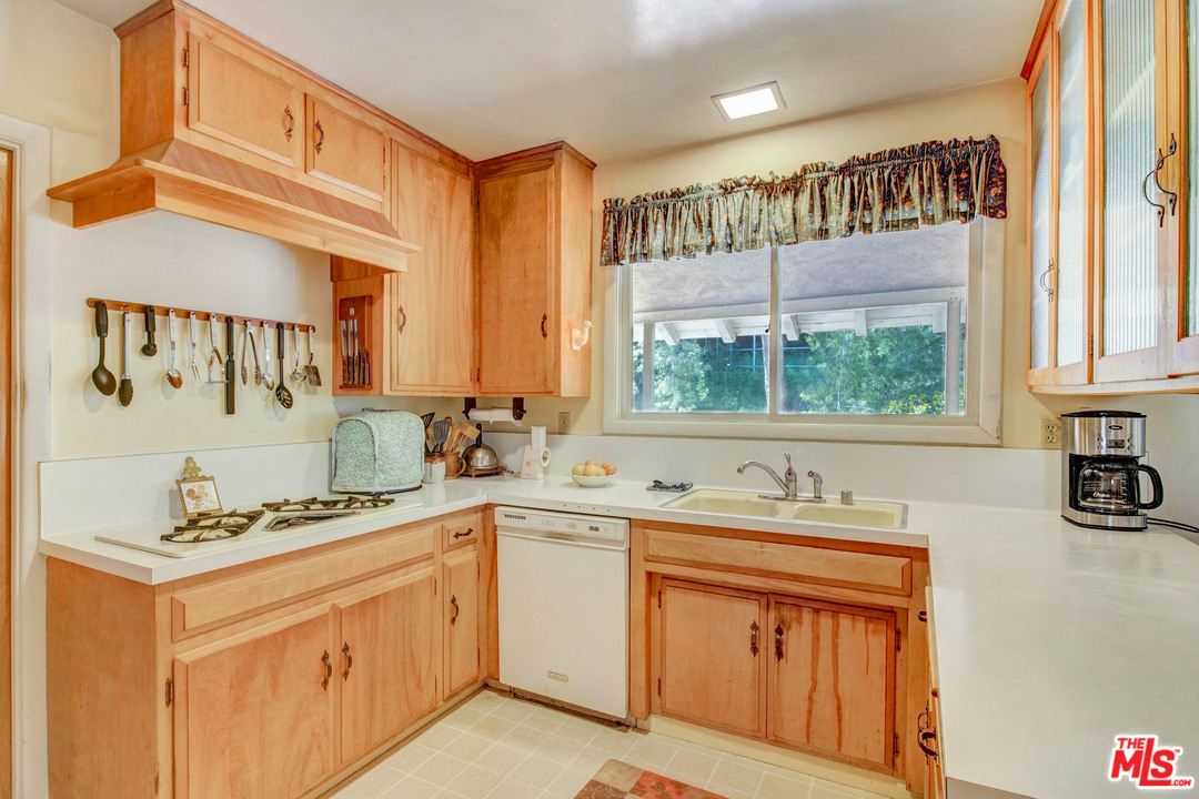 20490 Seaboard Road Malibu, CA 90265 - Photo 35 of 43 a kitchen with stainless steel appliances granite countertop a sink stove and cabinets
