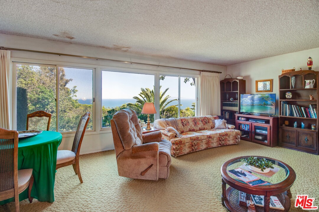 20490 Seaboard Road Malibu, CA 90265 - Photo 6 of 43 a living room with furniture and a book shelf