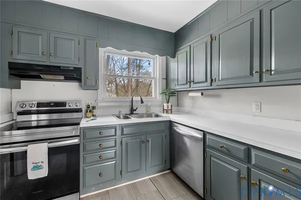 a kitchen with cabinets appliances a sink and a window