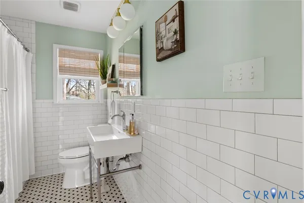 a bathroom with a sink toilet and mirror
