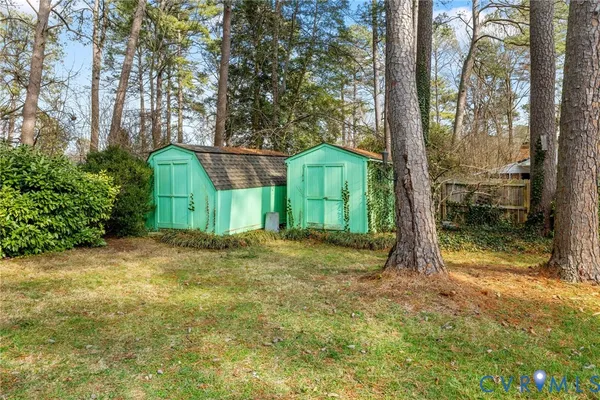 a view of a yard in front of a house with a large tree