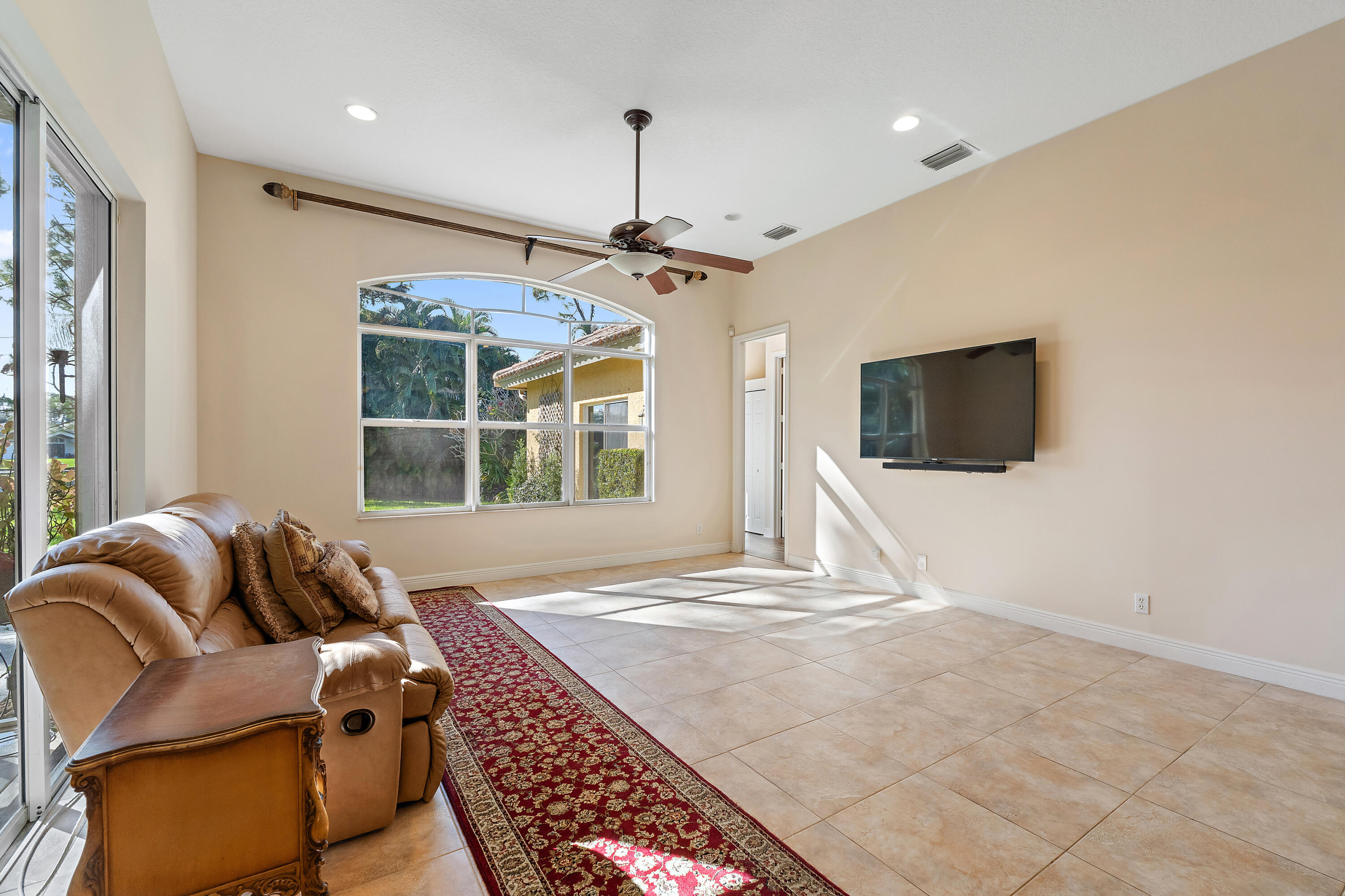 2650 Southwest Windship Way Stuart, FL 34997 - Photo 29 of 82 a living room with furniture a flat screen tv and a chandelier