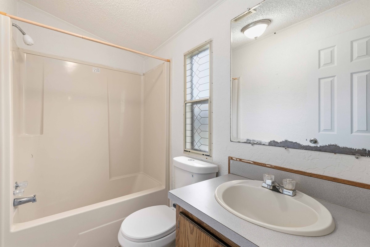 608 4th Street Blanket, TX 76432 - Photo 12 of 24 a bathroom with a sink toilet and shower