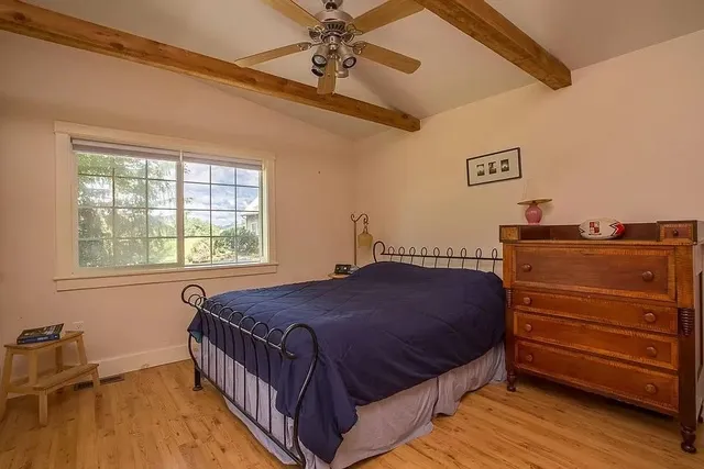 a bedroom with a bed and wooden floor