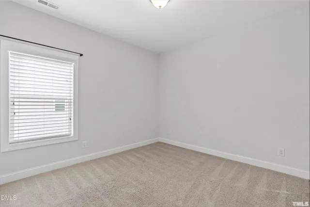 an empty room with fan and a fireplace