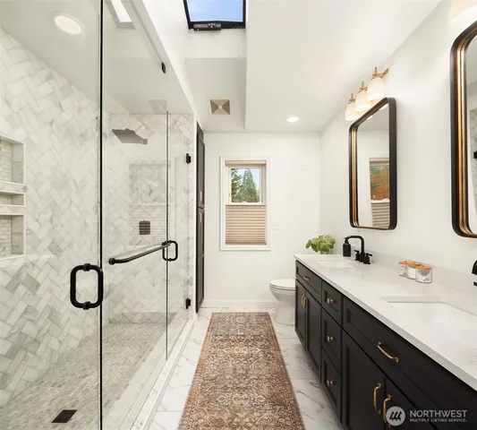 a bathroom with a double vanity sink a mirror and a shower