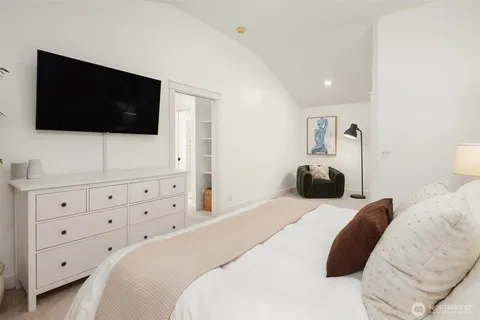a bedroom with a bed a flat screen tv and a couch