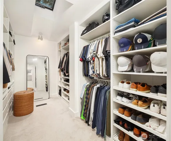 a view of walk in closet with clothes and shoes