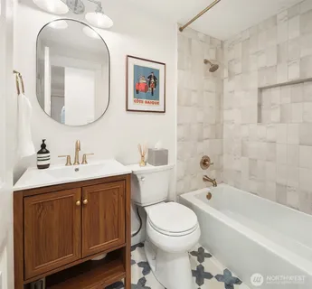 a bathroom with a toilet a sink a mirror and bathtub