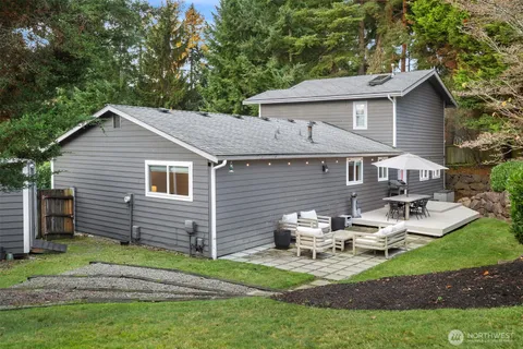 a view of backyard of house with outdoor seating and green space