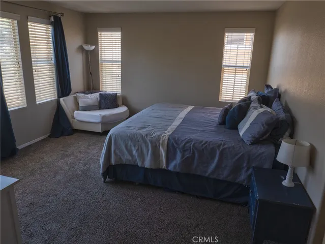 a bedroom with bed couch and window
