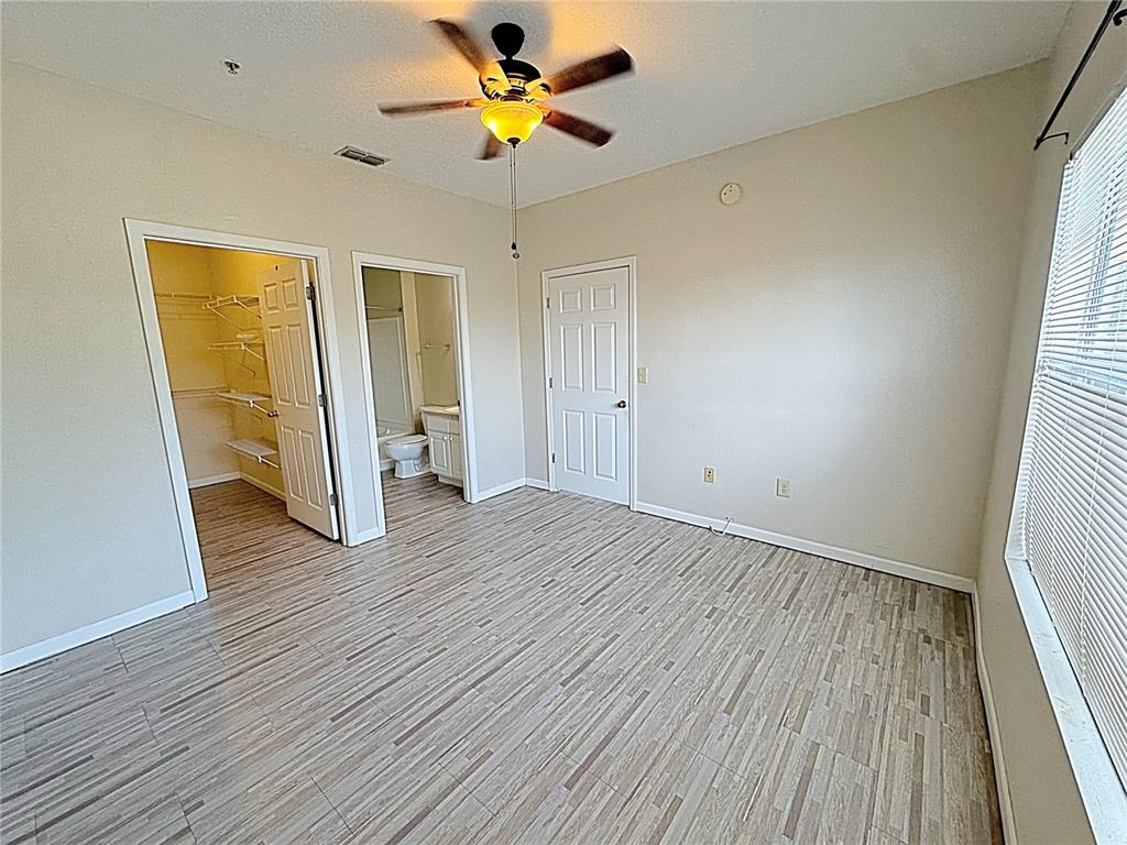 10764 70th Avenue, Unit 8201 Seminole, FL 33772 - Photo 14 of 37 a view of an empty room with wooden floor and a window