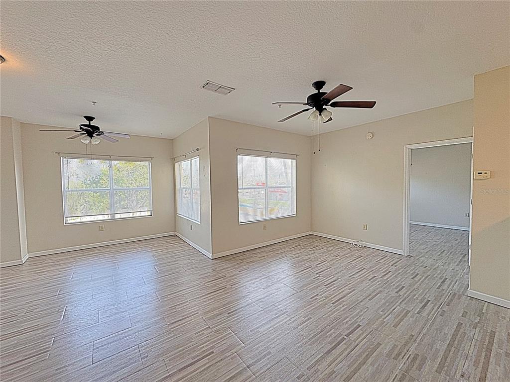 10764 70th Avenue, Unit 8201 Seminole, FL 33772 - Photo 3 of 37 a view of empty room with wooden floor and fan