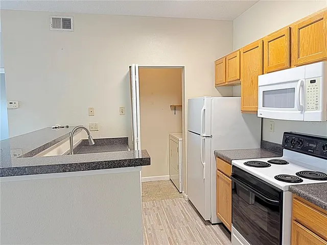 a kitchen with a sink stove and refrigerator