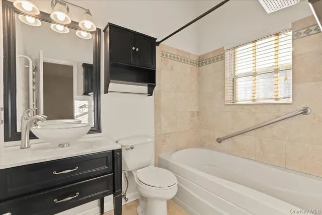 a bathroom with a sink a toilet a mirror and shower