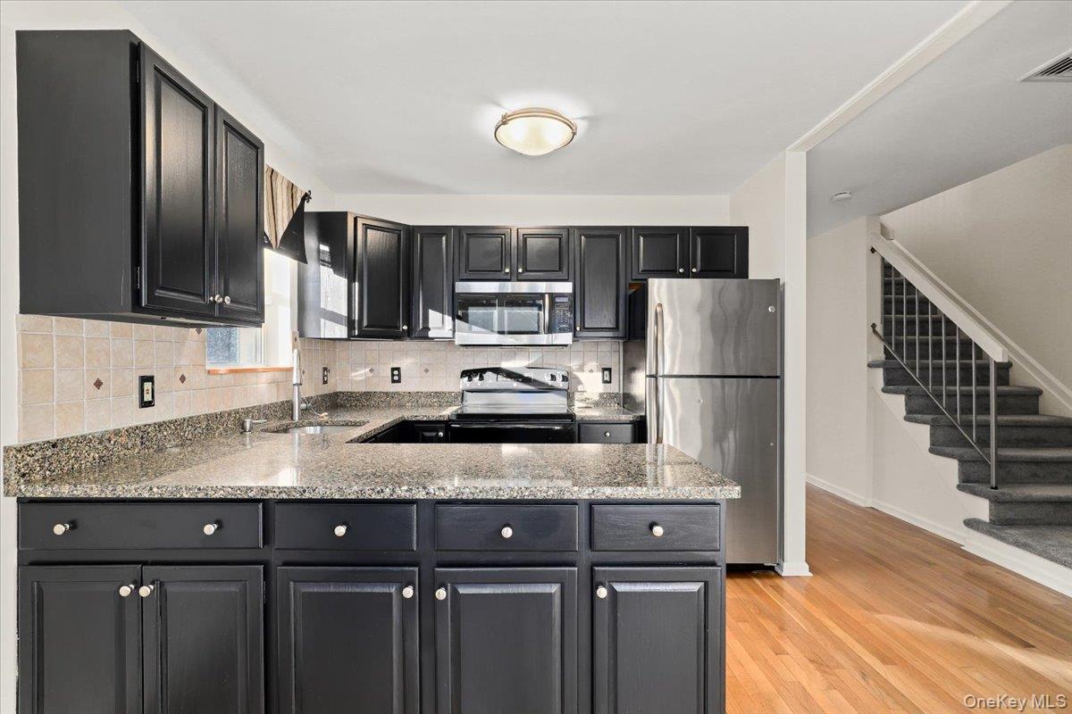 51 Hemlock Circle Peekskill, NY 10566 - Photo 3 of 21 a kitchen with a sink a microwave a refrigerator and cabinets