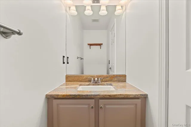 a bathroom with a granite countertop sink a toilet and a mirror