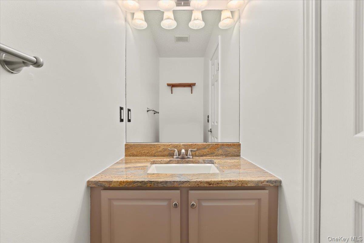 51 Hemlock Circle Peekskill, NY 10566 - Photo 5 of 21 a bathroom with a granite countertop sink a toilet and a mirror