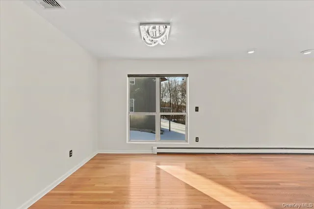 a view of a room with wooden floor and white walls