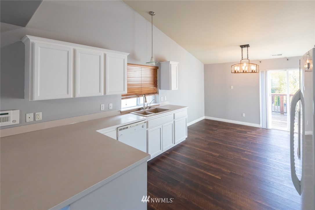 8317 49th Loop Southeast Olympia, WA 98513 - Photo 3 of 25 a kitchen with a sink a stove cabinets and wooden floor