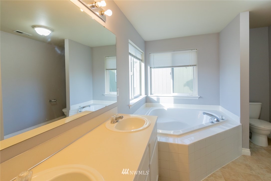 8317 49th Loop Southeast Olympia, WA 98513 - Photo 8 of 25 a bathroom with a tub sink and mirror
