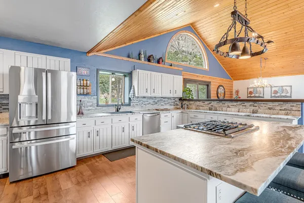 a kitchen with stainless steel appliances granite countertop a sink a stove and refrigerator