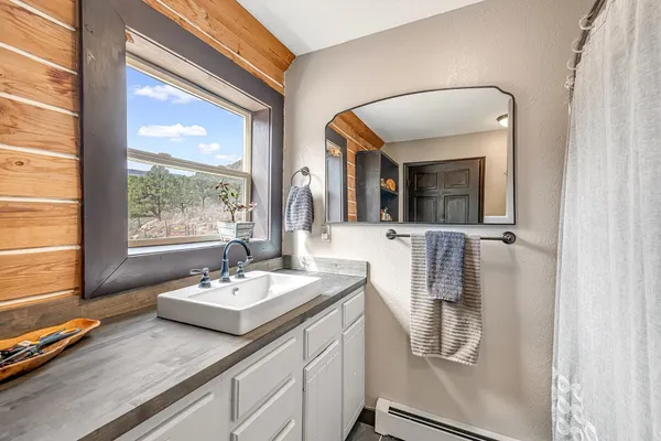 a bathroom with sink a mirror and a window