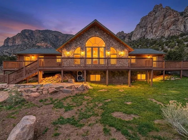 a view of a big house with a big yard and large tree
