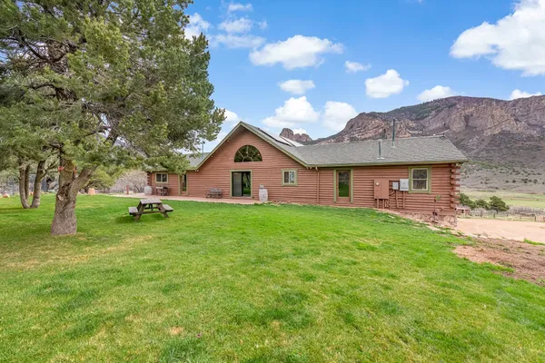 a view of a yard in front of a house with large trees