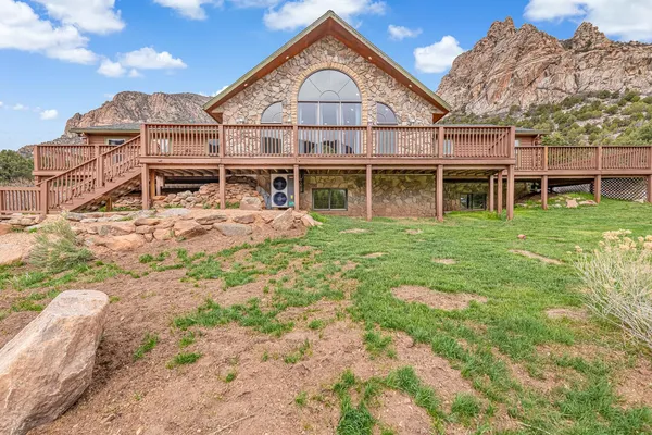 a view of a big house with a big yard and large tree