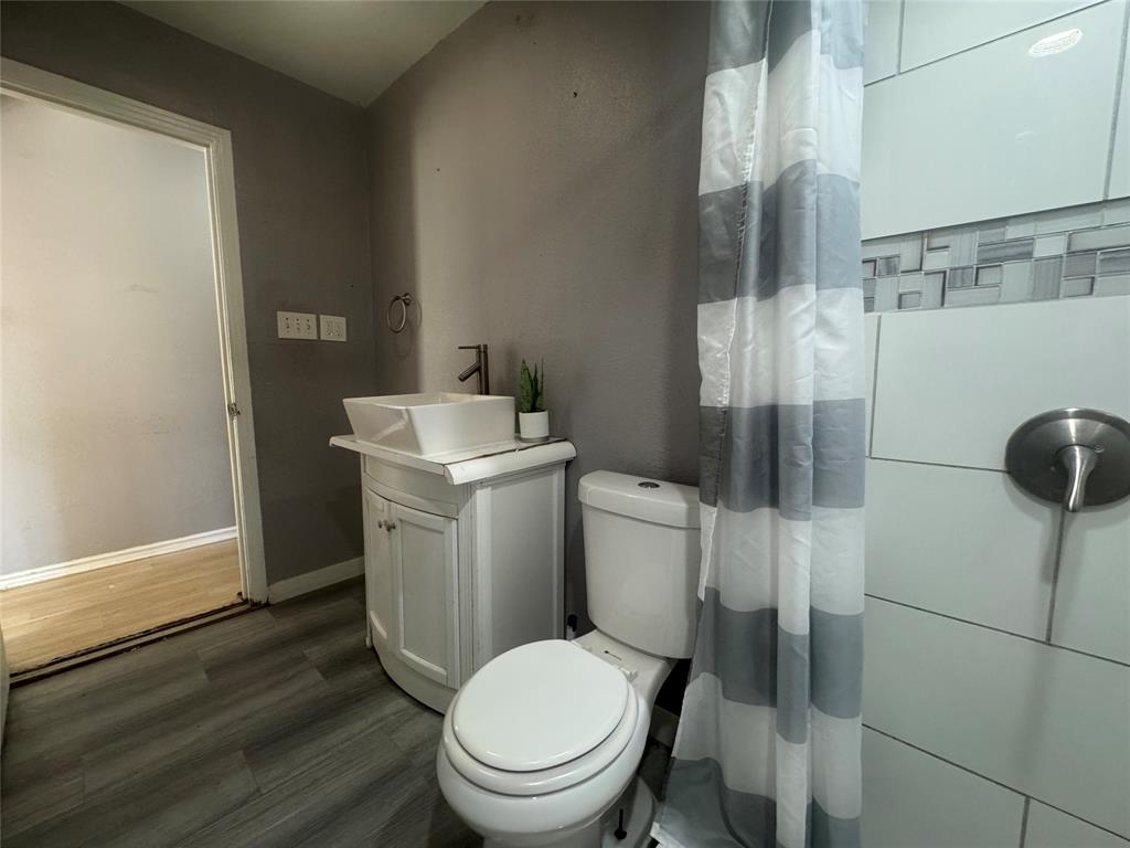 3520 Colcord Avenue Waco, TX 76707 - Photo 11 of 17 Bathroom featuring vanity, dark wood-style floors, and a shower with shower curtain
