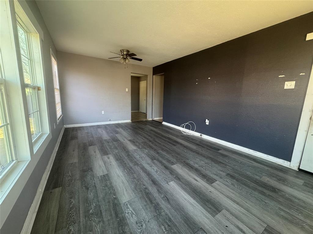 3520 Colcord Avenue Waco, TX 76707 - Photo 3 of 17 Empty room with ceiling fan and dark wood-style flooring