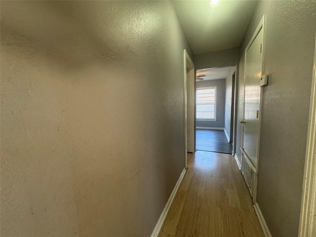 3520 Colcord Avenue Waco, TX 76707 - Photo 9 of 17 Hallway featuring light wood-style floors and a textured wall