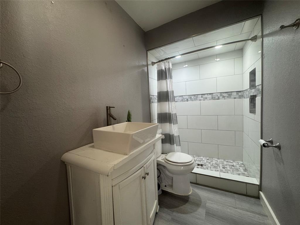 3520 Colcord Avenue Waco, TX 76707 - Photo 10 of 17 Bathroom with a textured wall, vanity, and a stall shower
