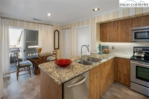 a kitchen with granite countertop a sink stove and cabinets