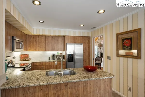 a kitchen with stainless steel appliances granite countertop a sink refrigerator and stove