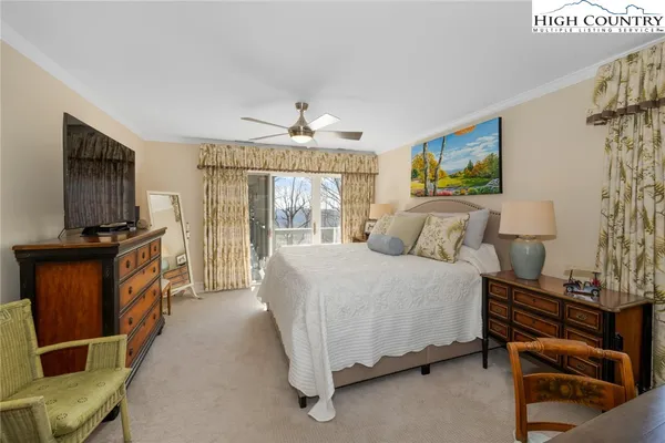 a spacious bedroom with a bed and a flat screen tv